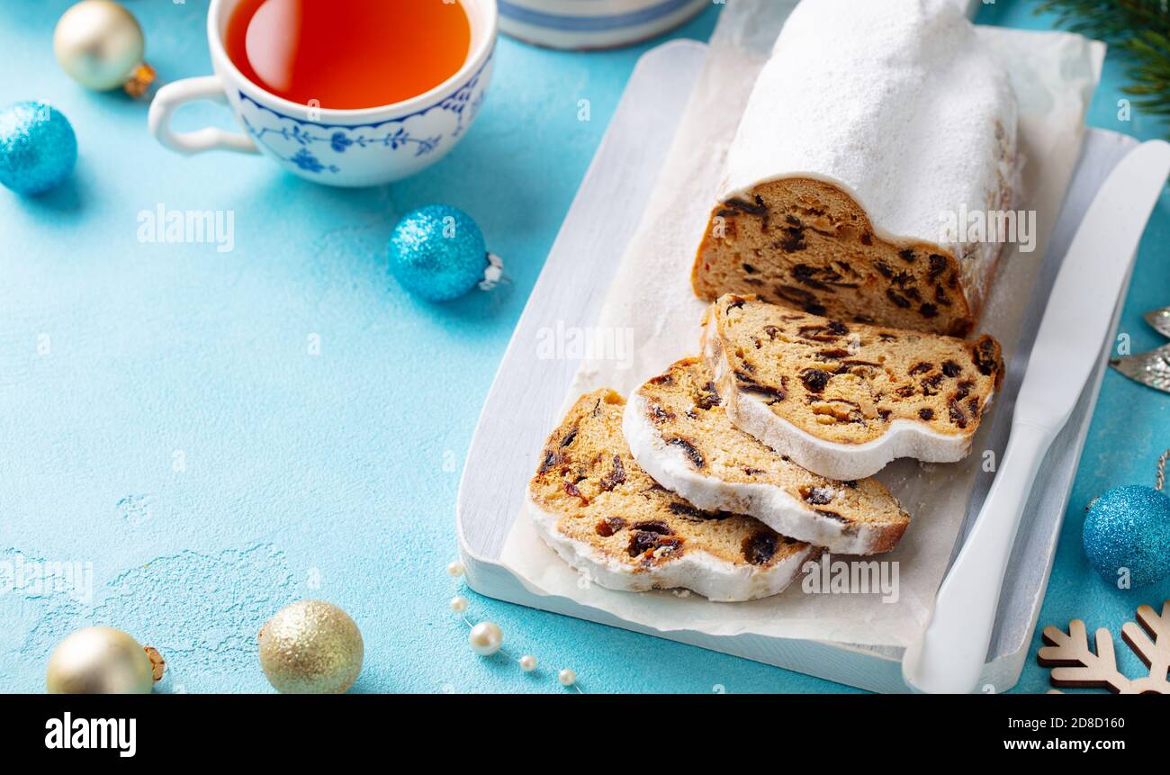 Christmas stollen. Traditional German festive dessert with cup of tea. Blue background. Copy space. Stock Photo
