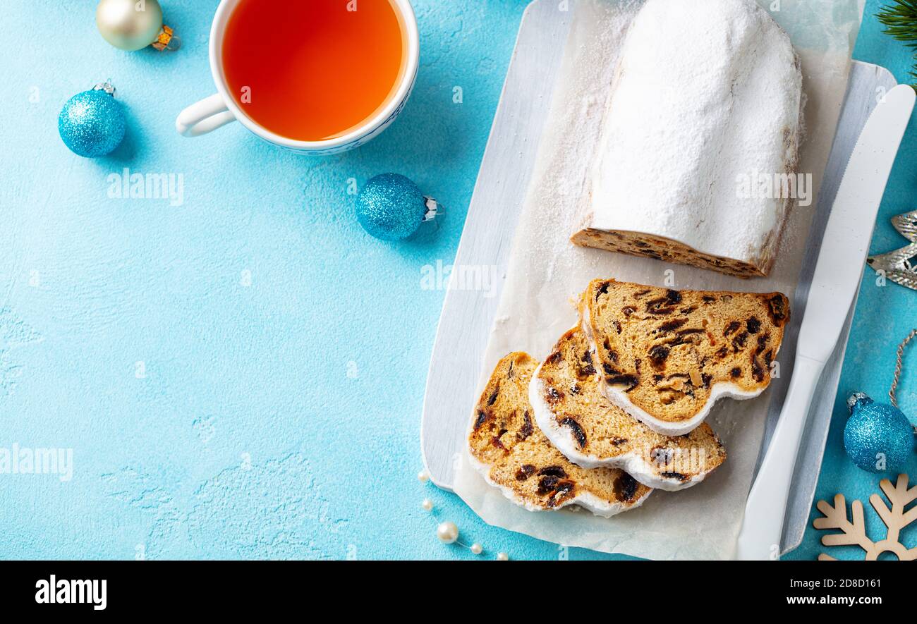 Christmas stollen. Traditional German festive dessert with cup of tea. Blue background. Copy space. Top view. Stock Photo