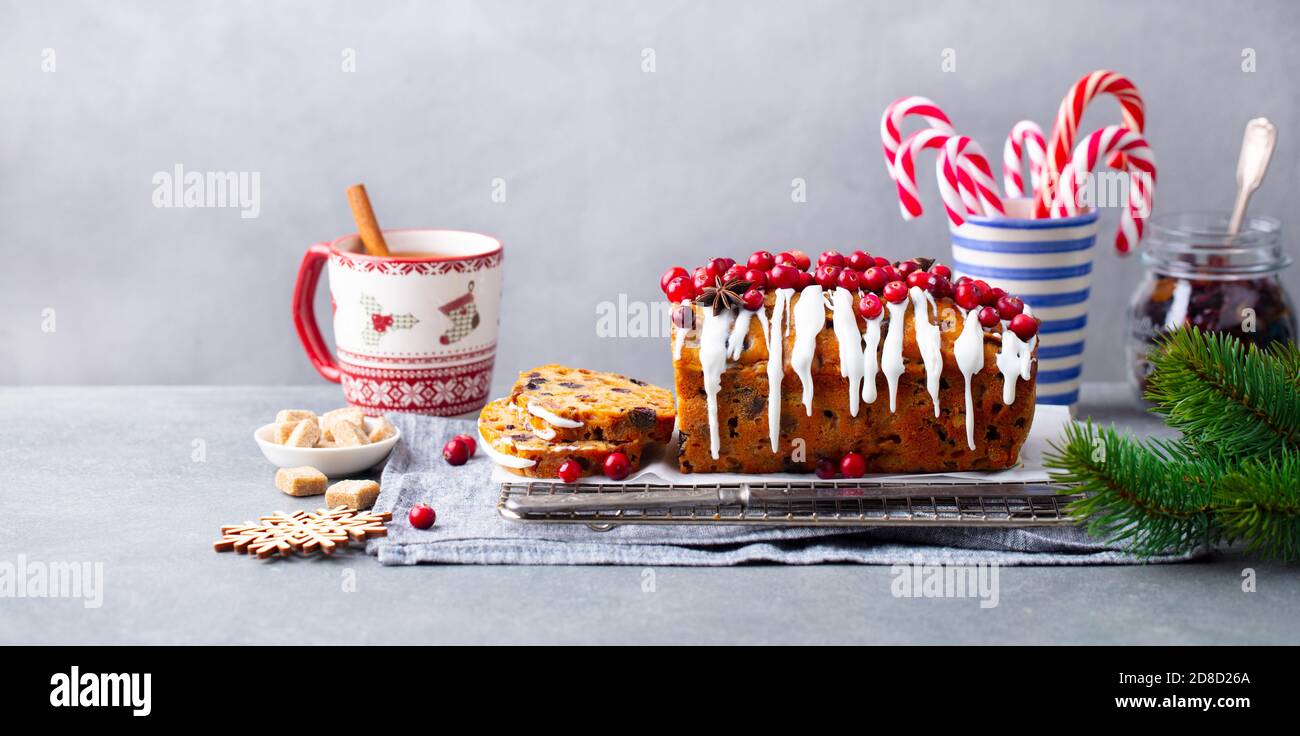 Christmas fruit cake, loaf on cooling rack with cup of tea. Grey background. Copy space. Stock Photo