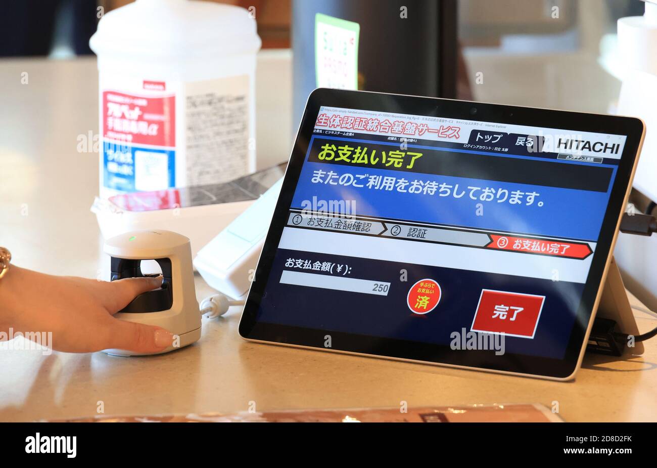 Yokohama, Japan. 29th Oct, 2020. An employee of Japanese electronics giant  Hitachi inserts her finger to a finger vein scanner as she buys coffee for  a demonstration of empty-handed cashless payment system