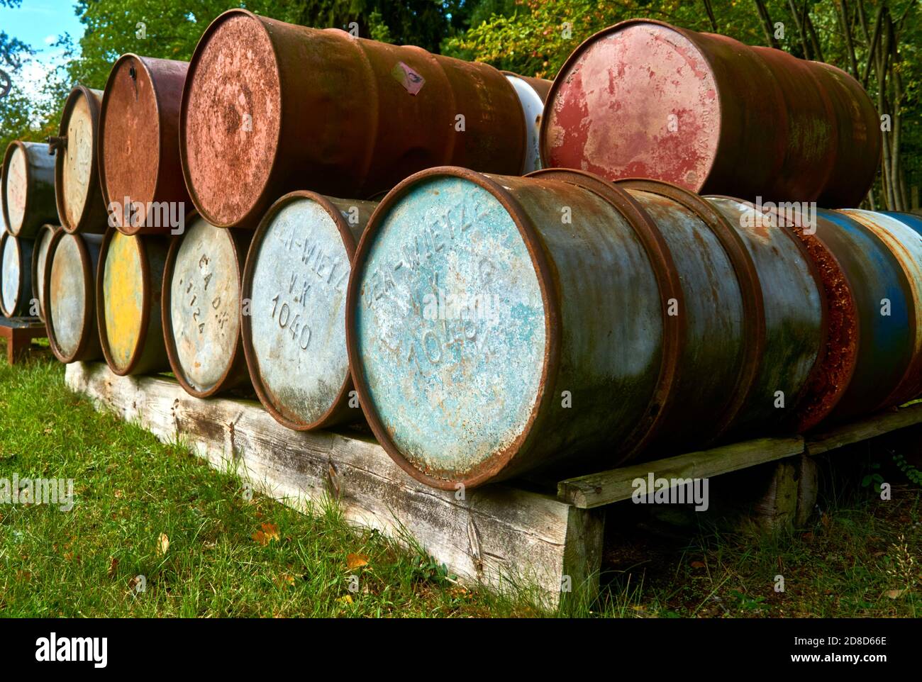 Wietze, Germany, September 10., 2020: Old empty oil barrels on a solid wood Euro pallet Stock Photo