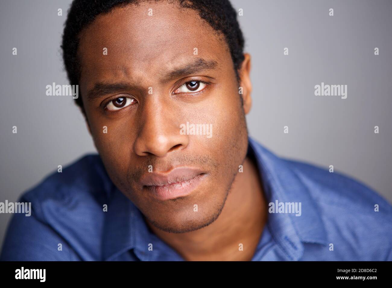 Close up portrait of serious young african american man against gray ...
