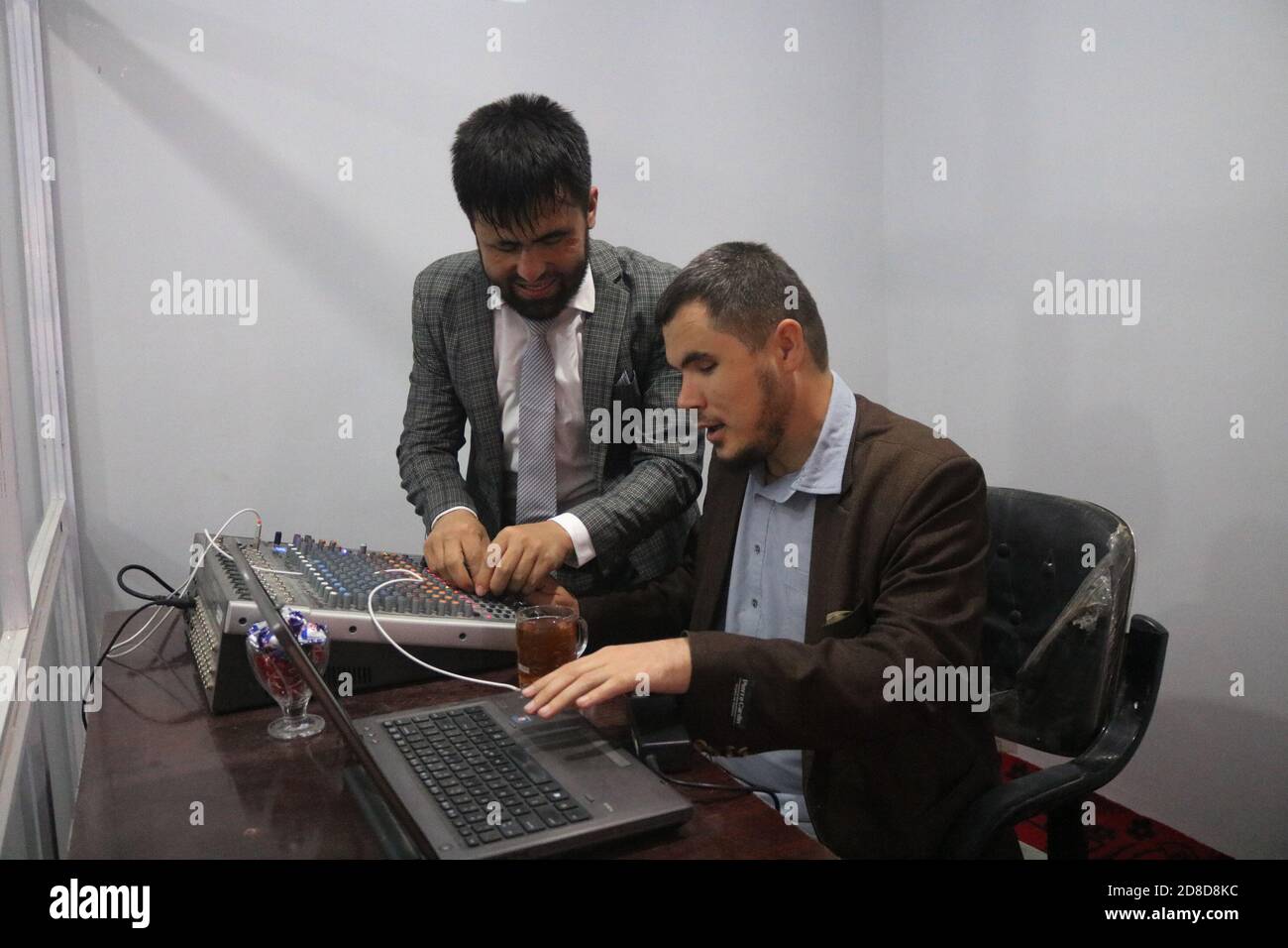 Shiberghan, Afghanistan. 18th Oct, 2020. Musawir Shija (L), the founder of  an FM radio station, works at his station office in Shiberghan, capital of  Jawzjan province, northern Afghanistan, Oct. 18, 2020. TO