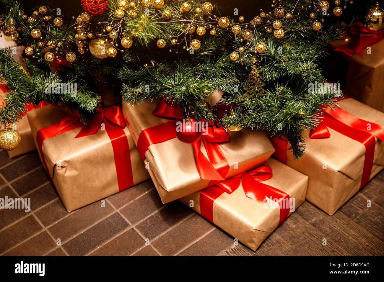 Beautiful Christmas gift boxes on floor near fir tree in the room Stock ...