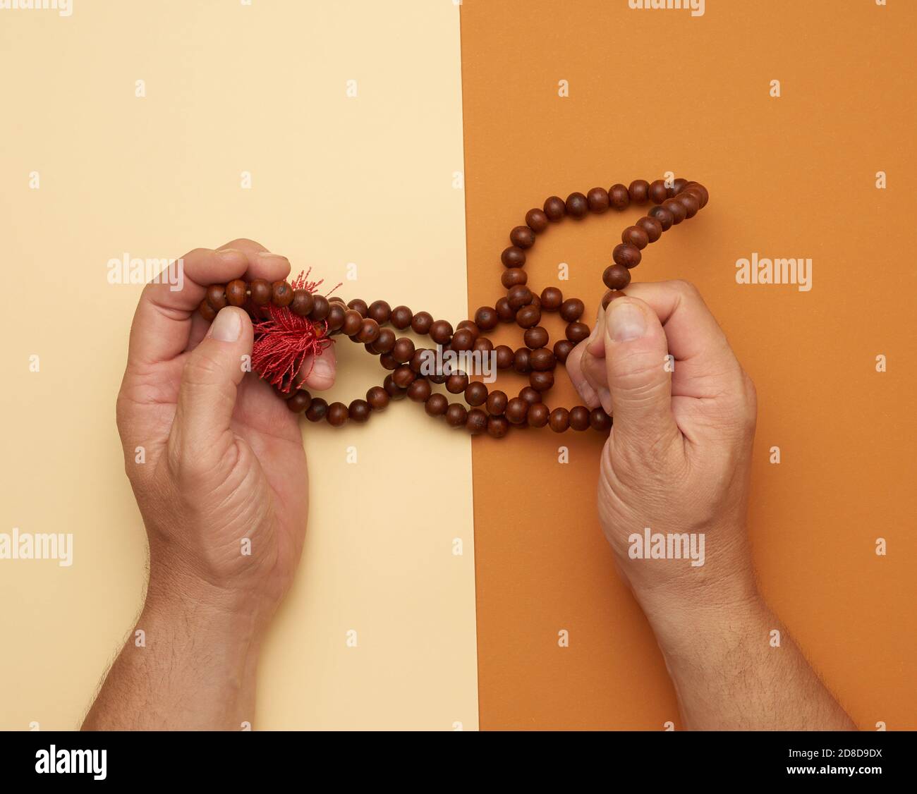 two male hands hold wooden prayer beads, top view Stock Photo