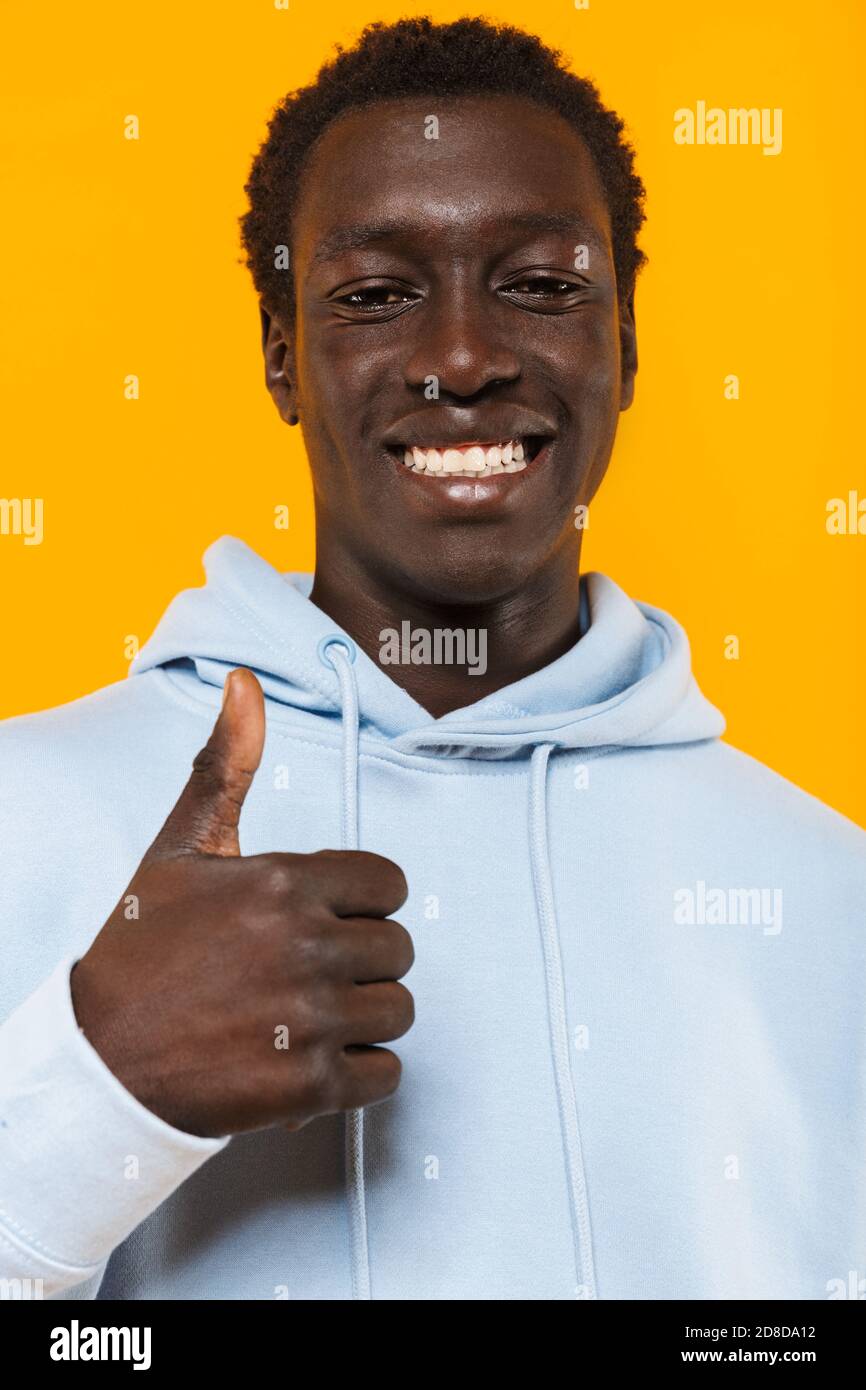Image of pleased african american guy in streetwear hoodie smiling and ...