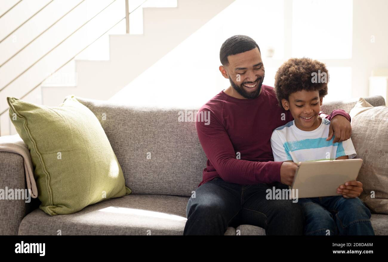 Man and son using digital tablet at home Stock Photo
