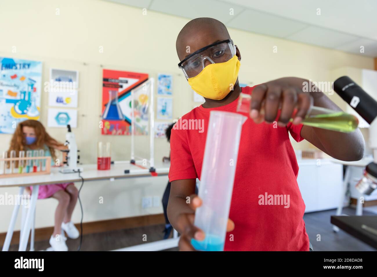 Boy wearing face mask and protective glasses mixing chemicals in