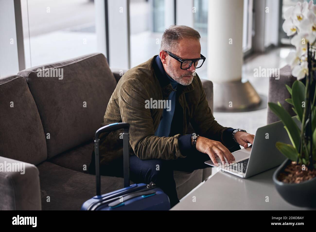 Serious bearded man using his computer indoors Stock Photo