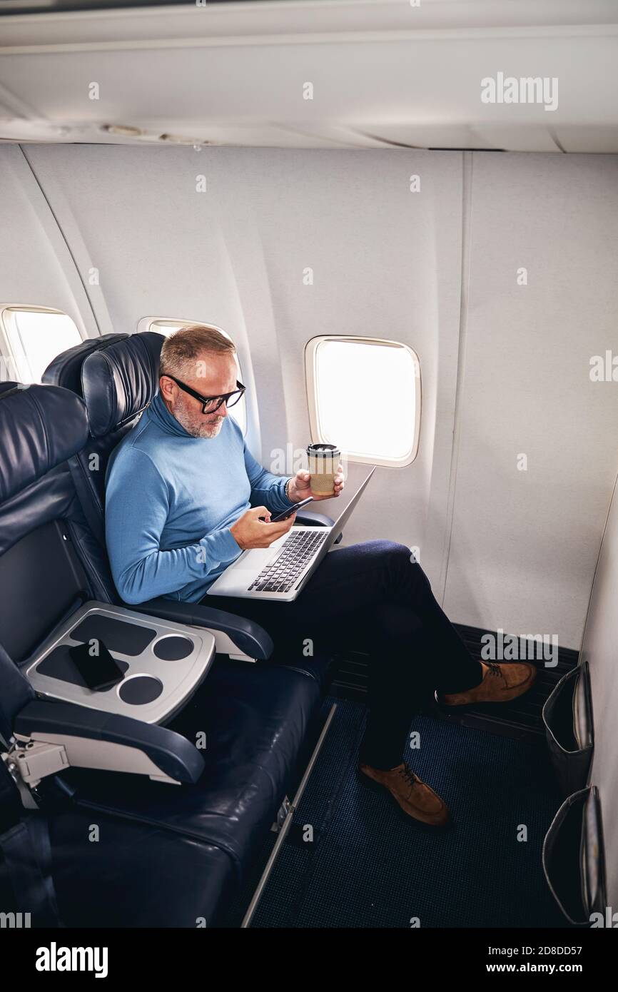 Concentrated airline passenger working during the flight Stock Photo
