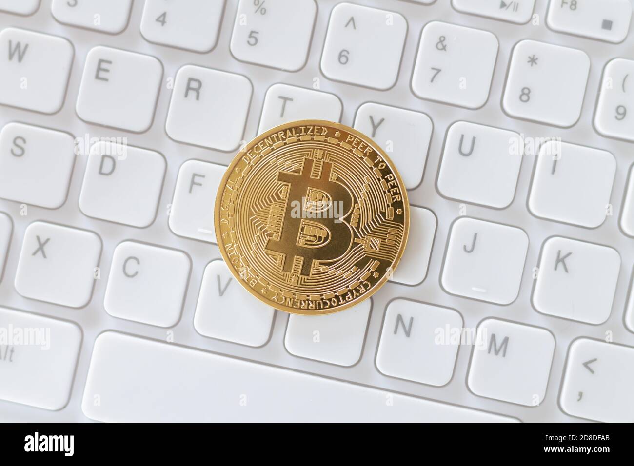 Cryptocurrency gold bitcoin on white keyboard. Virtual cryptocurrency concept Stock Photo