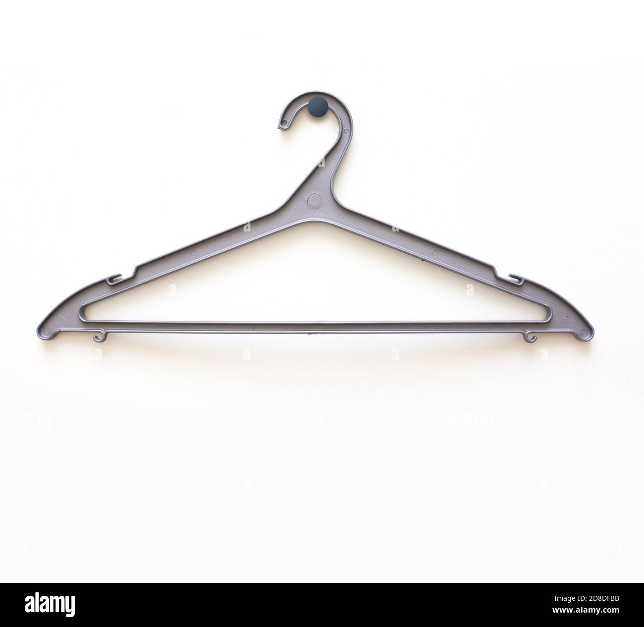 White wooden hanger hanging on a hook on a white wall Stock Photo - Alamy