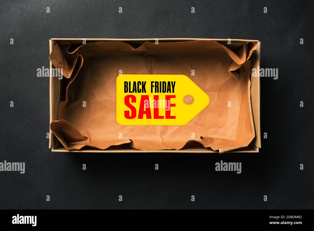 Black Friday sale. Open empty box with a tag on a dark background. Stock Photo