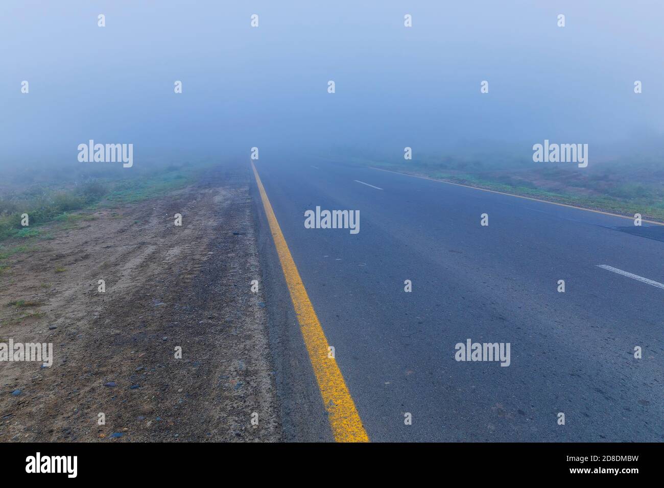 Asphalt road leaving in autumn fog Stock Photo - Alamy