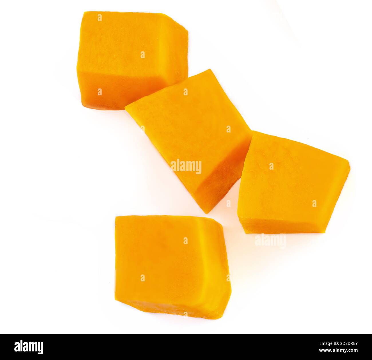 Diced Pumpkin  isolated on white background.  Fresh Pumpkin pieces cut in a cube slice, top view. Flat lay Stock Photo