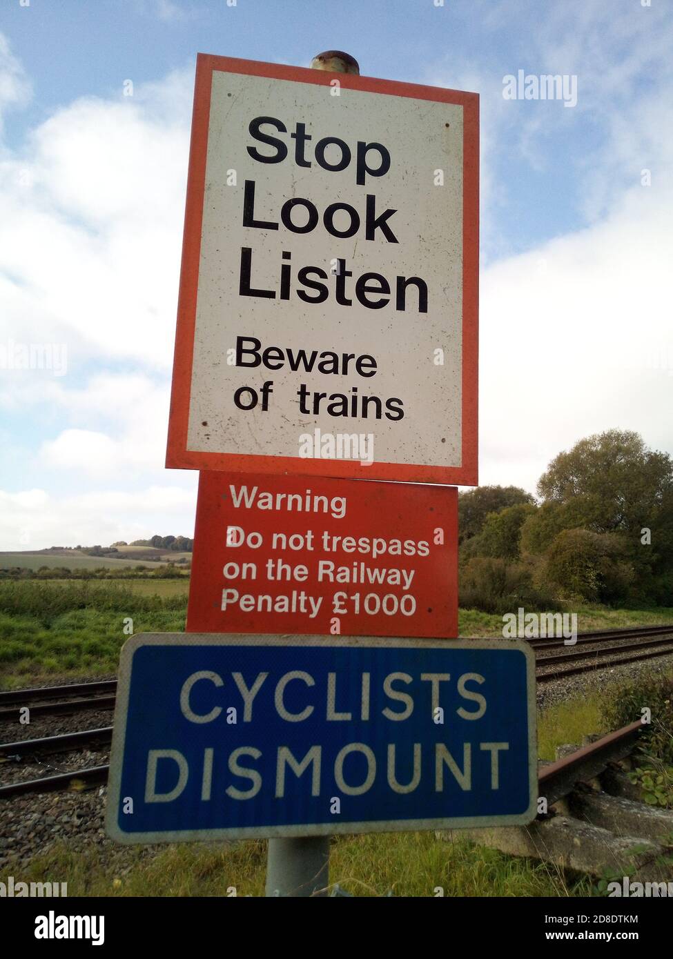 warning and information signs by manually operated railway level crossing in the UK Stock Photo