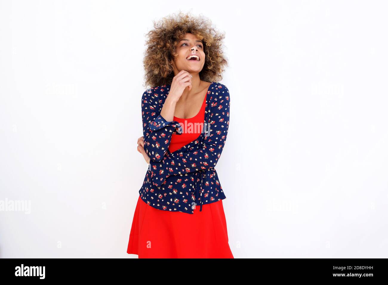 Portrait of happy young african american woman laughing by white ...