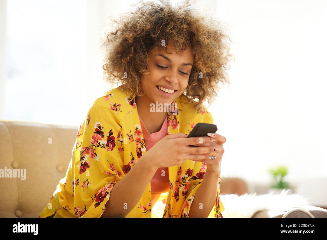 Portrait of beautiful african american woman using cellphone at home ...