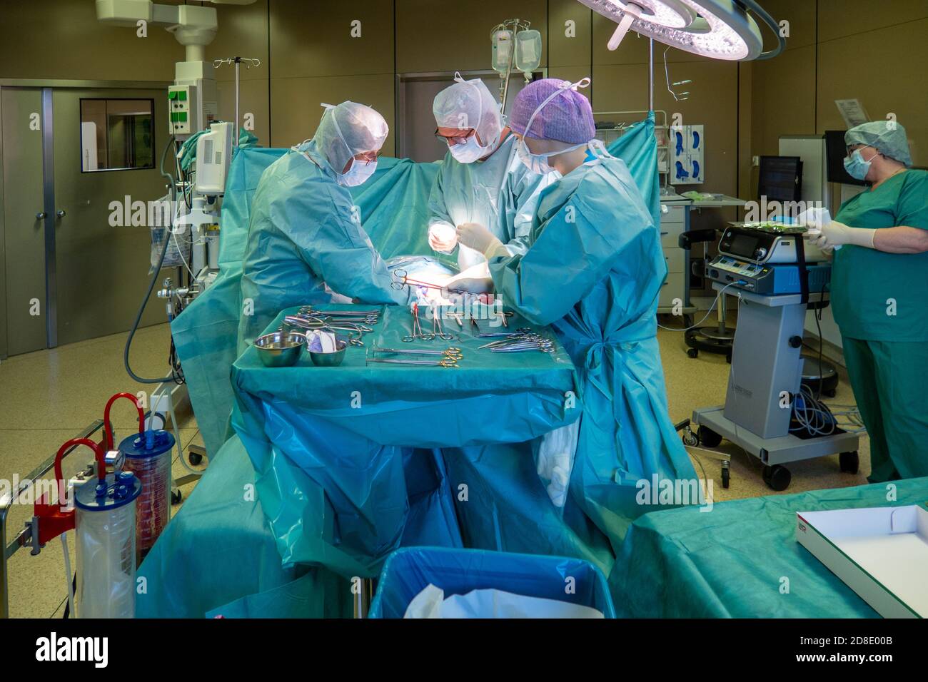 a team of gynecologists performs a caesarean section in an operating ...