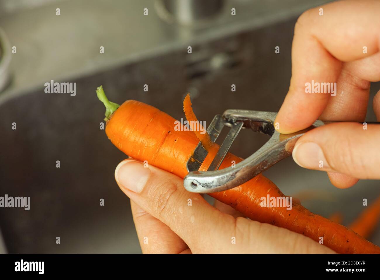 https://c8.alamy.com/comp/2D8E0YR/person-peeling-a-carrot-with-a-peeler-close-up-2D8E0YR.jpg