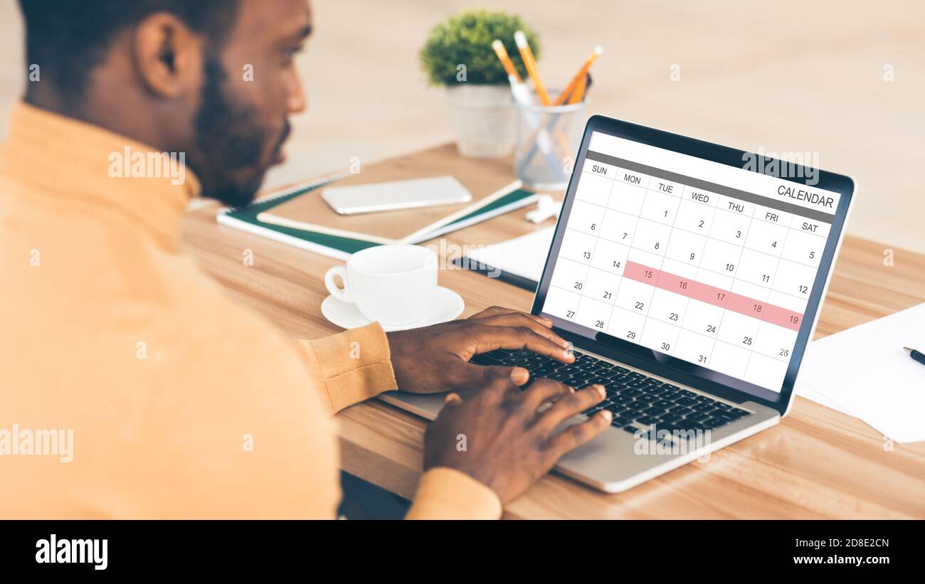 Black Businessman Checking Calendar In Laptop At Workplace, Planning