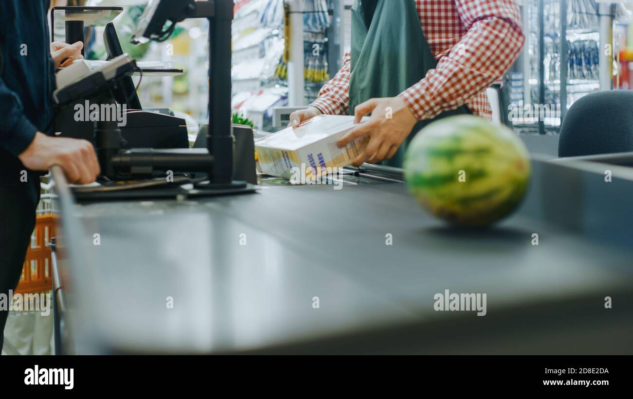 At the Supermarket: Checkout Counter Hands of the Cashier Scans Groceries, Fruits and other Healthy Food Items. Clean Modern Shopping Mall with Stock Photo