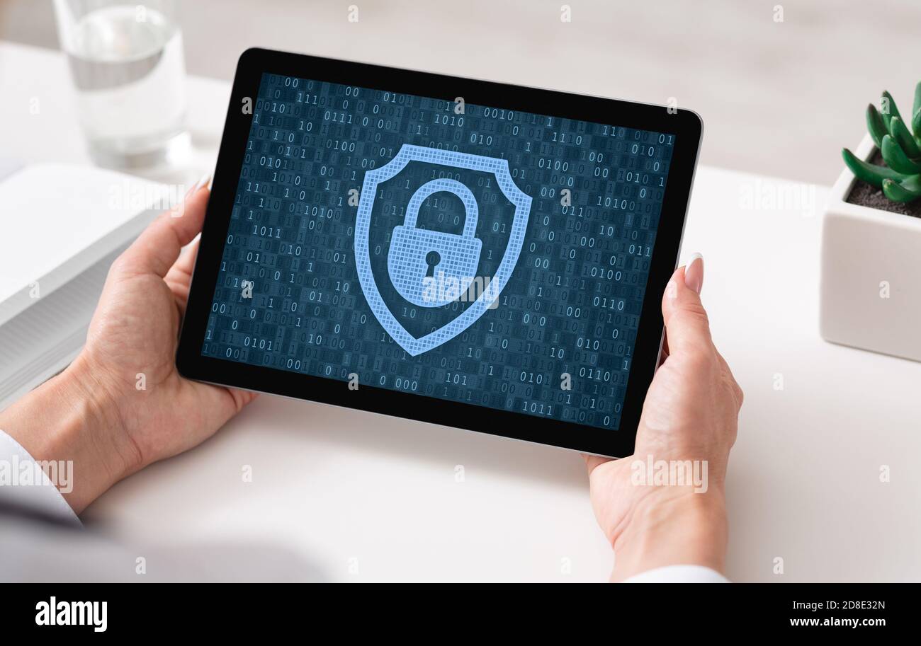 Woman using tablet, padlock icon on blue screen Stock Photo