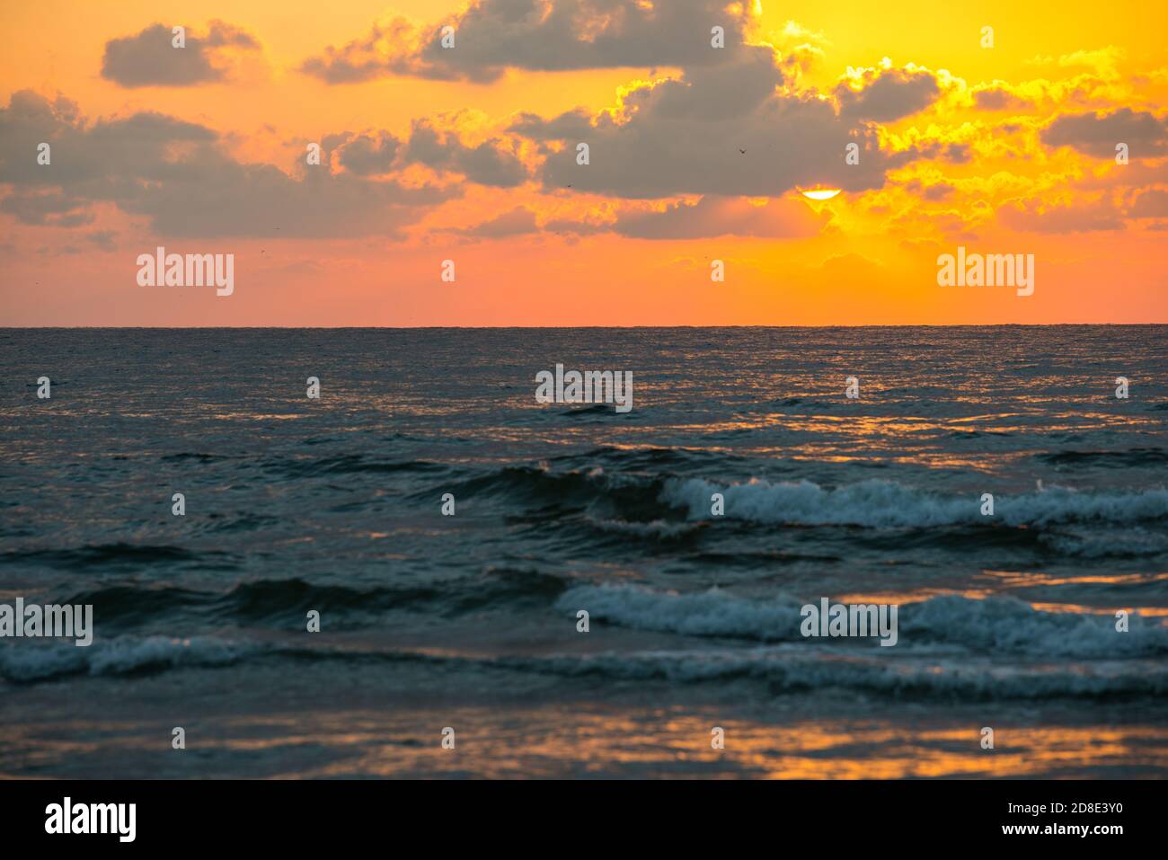Beautiful orange sky with clouds at sunrise on the beach at sea Stock ...