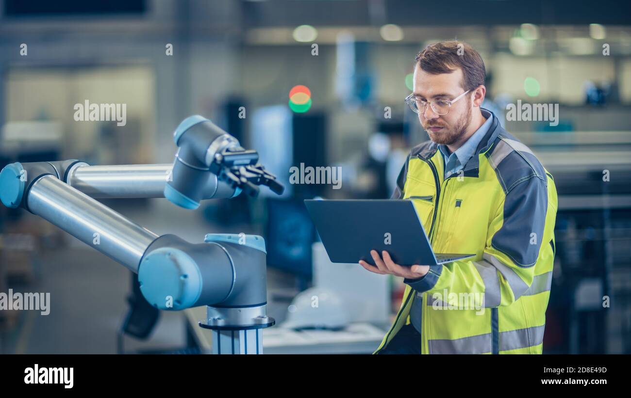 Uses laptop for programming robotic arm hi-res stock photography and ...
