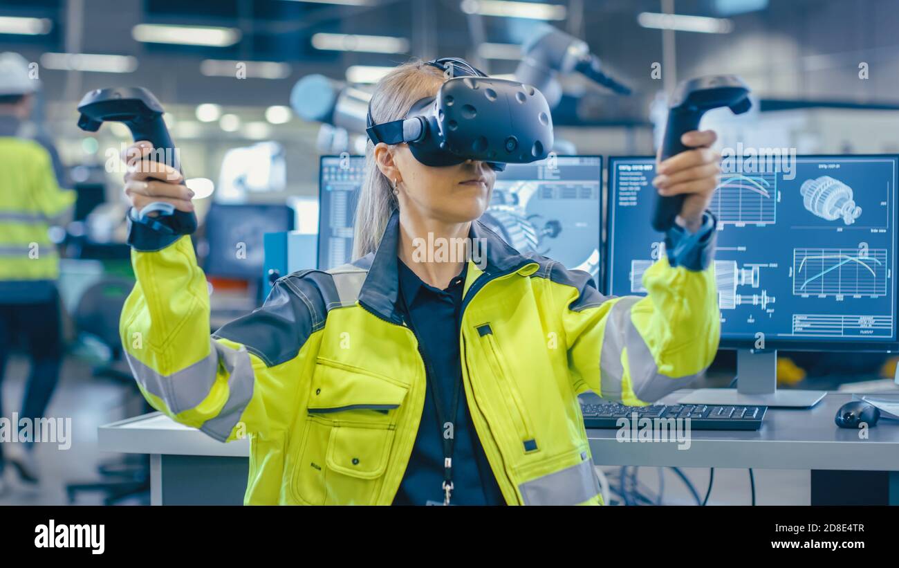 Portrait Female Mechanical Engineer Wearing Virtual Reality Headset and Making Gestures with Controllers, She Uses VR technology for Industrial Design Stock Photo