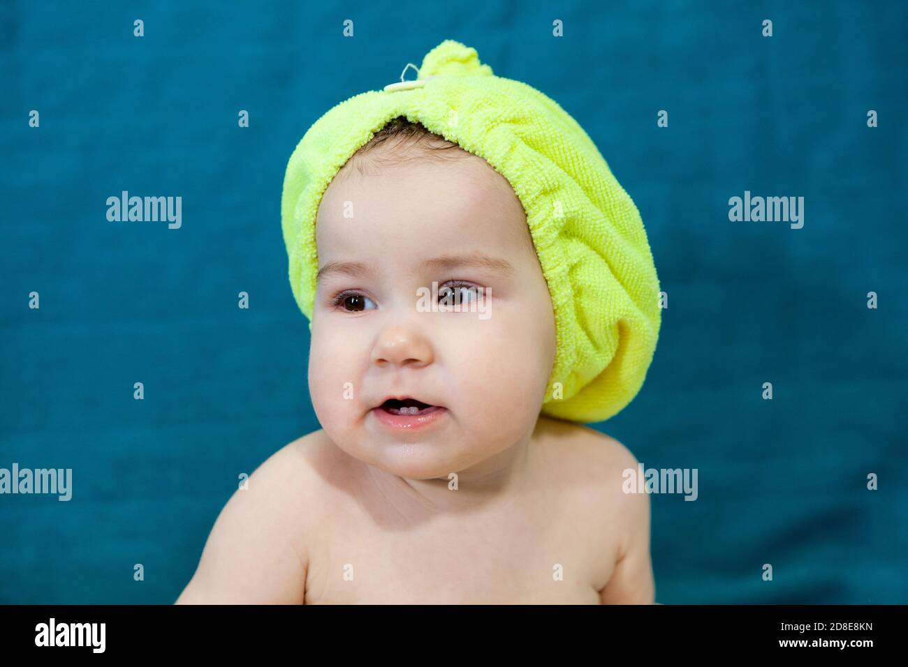 Cute baby girl with yellow towel as hat after bath on head. Caucasian