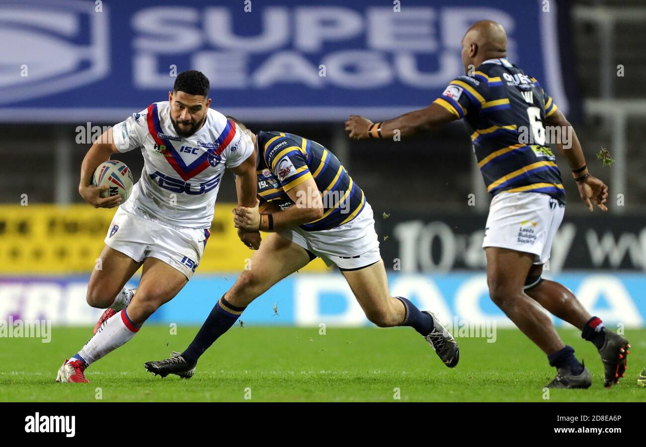 Wakefield Trinity's Kelepi Tanginoa (left) runs at the Leeds Rhinos defence during the Betfred Super League match at the Totally Wicked Stadium, St Helens. Stock Photo