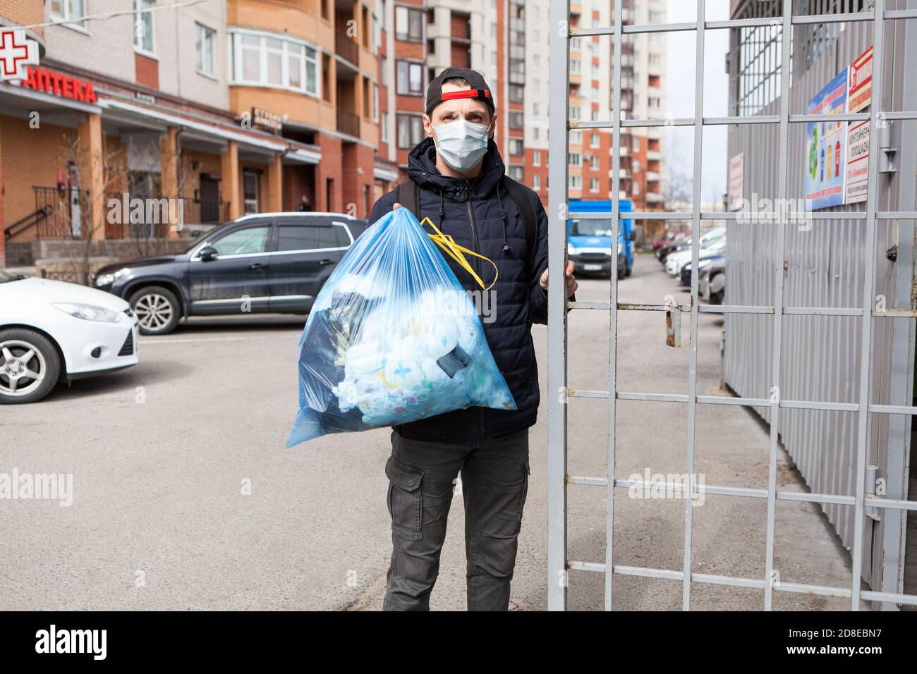 Adult man taking out garbage during coronavirus pandemic, it is allowed without any permission Stock Photo