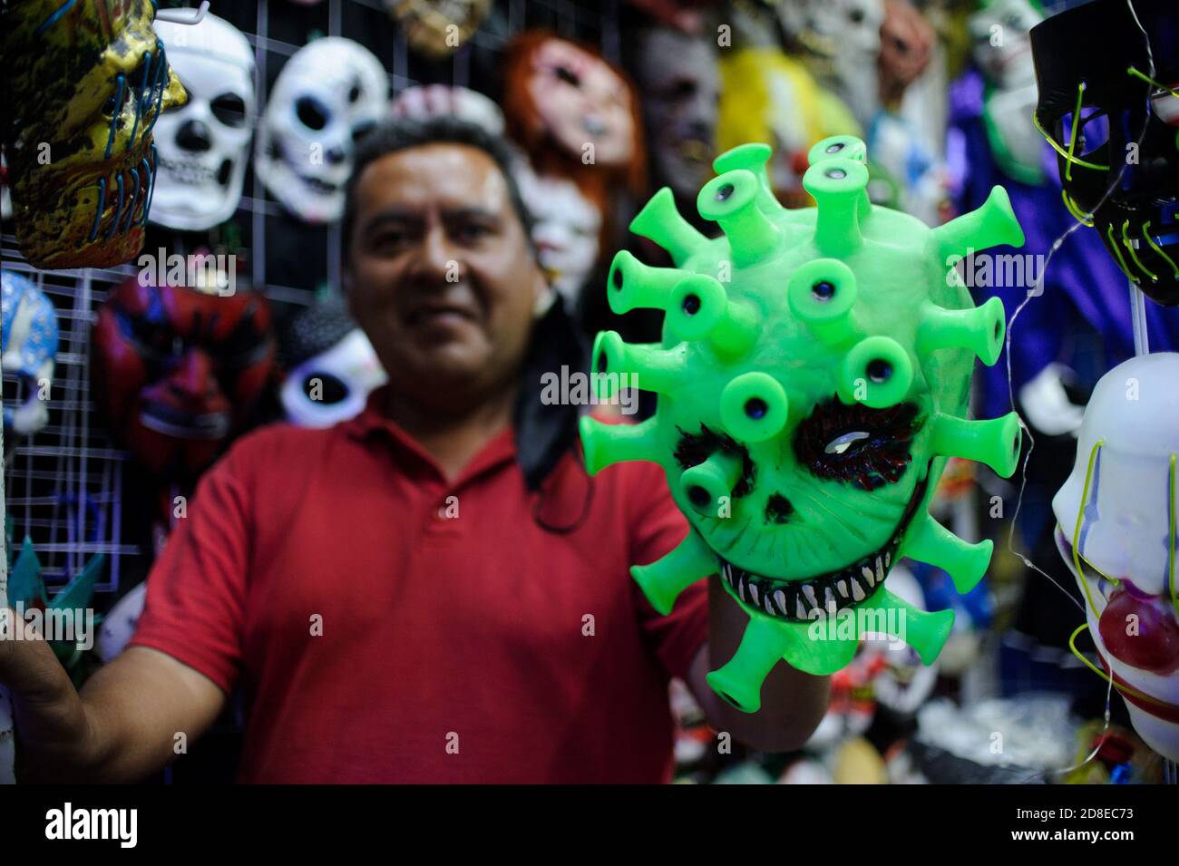 Tlaxcala, Mexico. 29th Oct, 2020. A seller shows a mask with the motive 'Coronavirus' before the day of the dead and Halloween. The Day of the Dead is a big celebration in Mexico. This year, corona-related restrictions are to apply nationwide. Credit: Jesus Alvarado/dpa/Alamy Live News Stock Photo