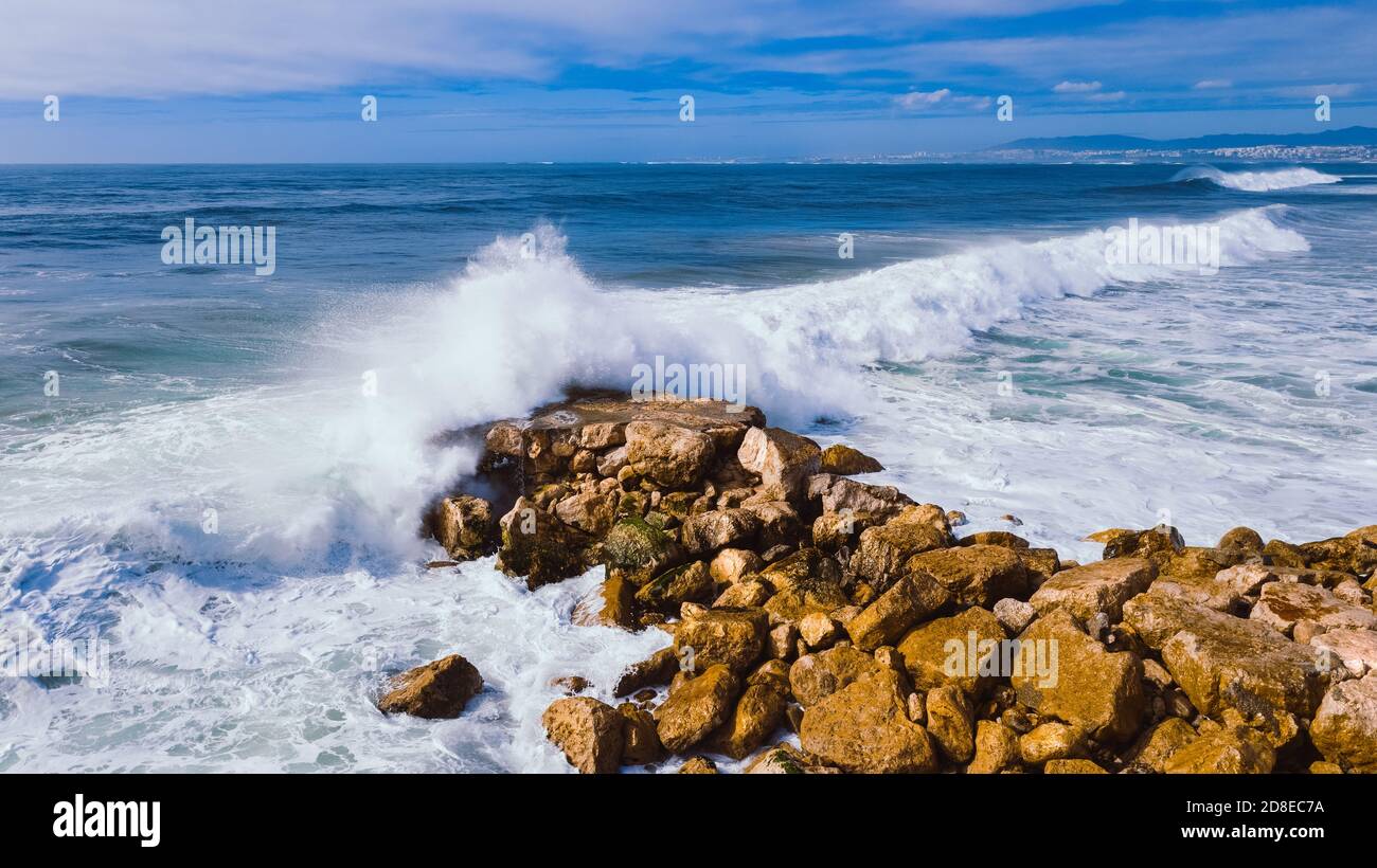 Aerial top view of Atlantic ocean big waves hitting on stone waterbreak  Stock Photo