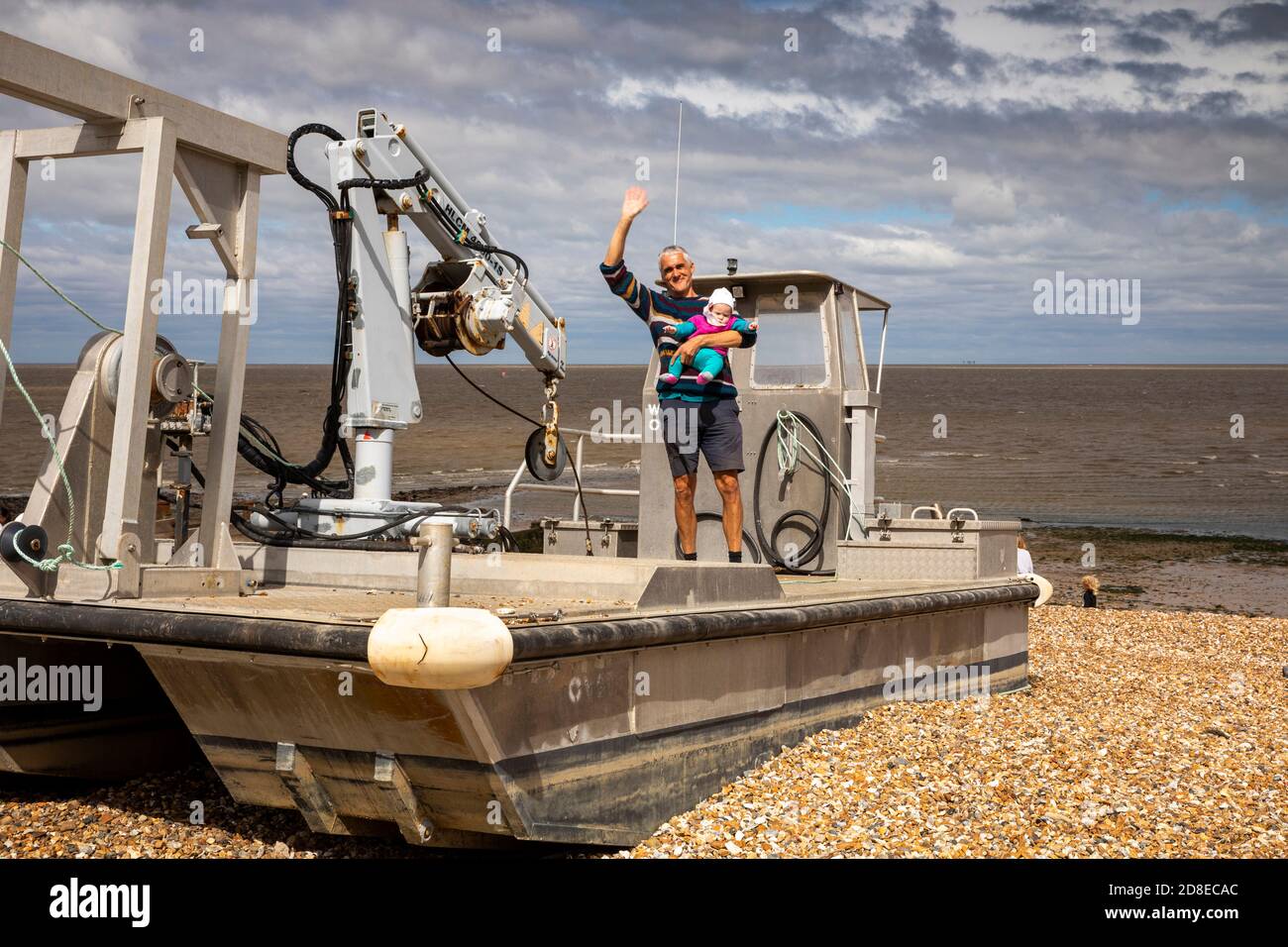 UK, Kent, Whitstable, Harbour, East Quay, man with baby on oyster fishing boat Stock Photo