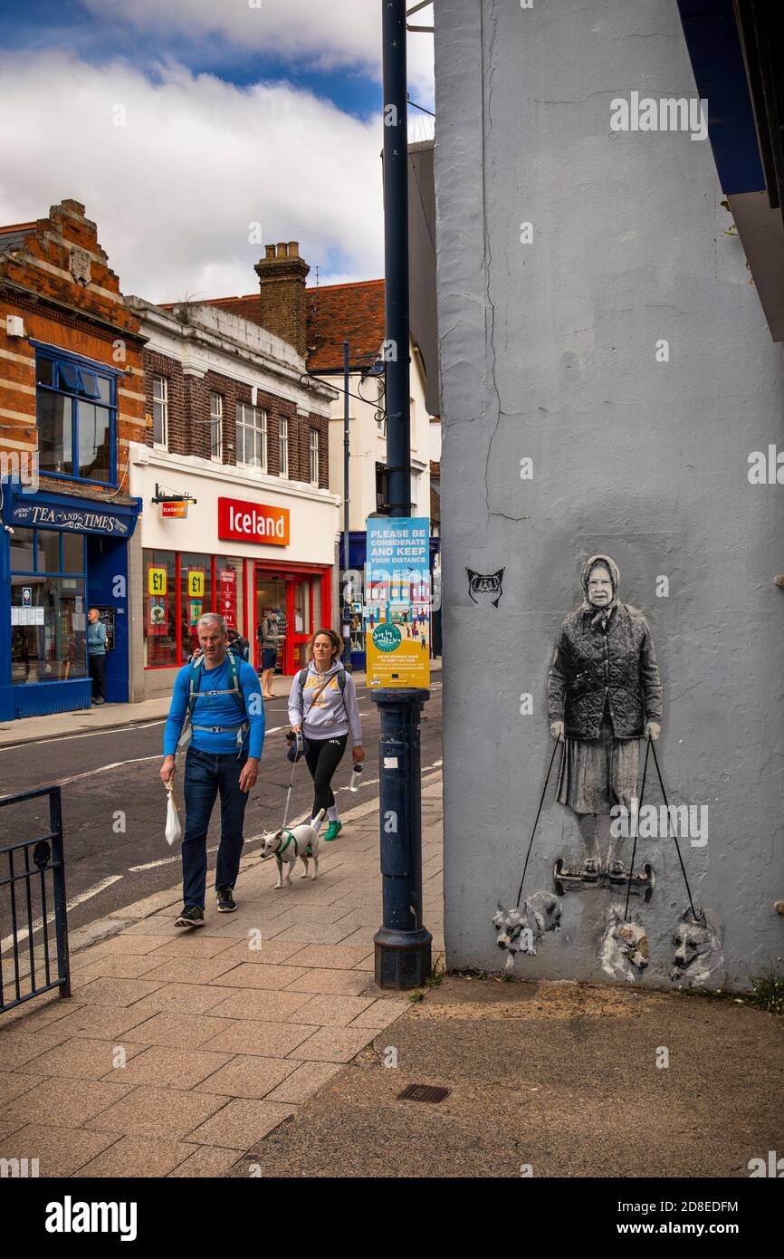 UK, Kent, Whitstable, High Street, dog walker walking past queen