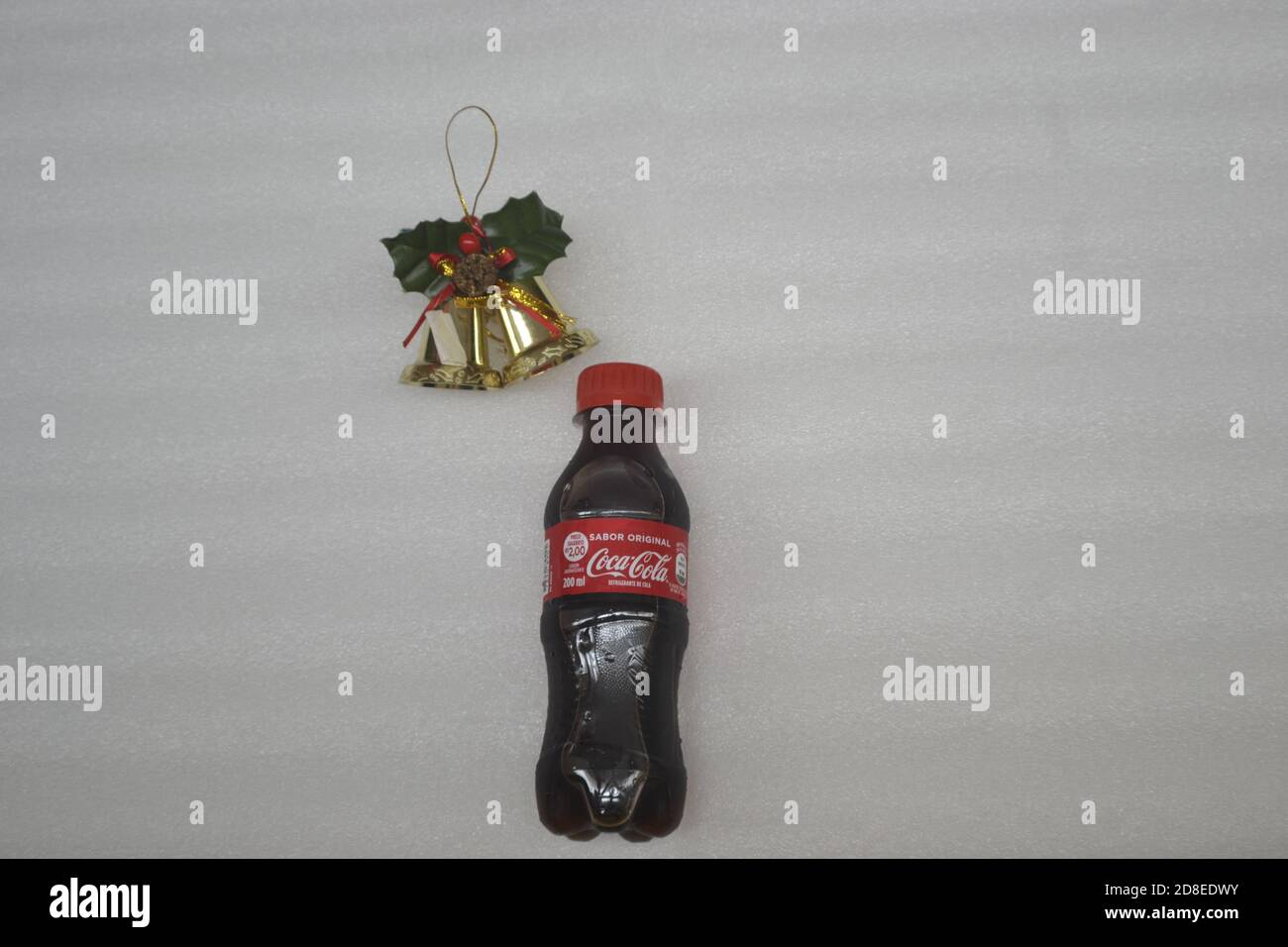 Soda bottle. Mini promotional plastic bottle from a multinational company, with Christmas bells, white background, with red cap, Brazil, South America Stock Photo