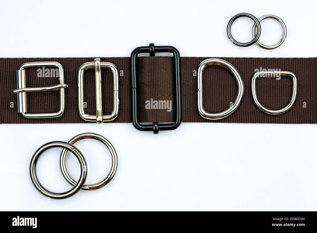 Brown belt with adjusters, buckles, rings, half rings top view. Metal