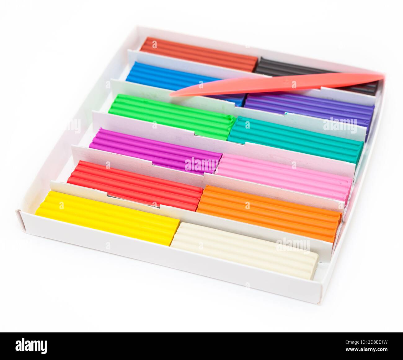 Cardboard box with colorful plasticine bars and plastic knife, a white background Stock Photo
