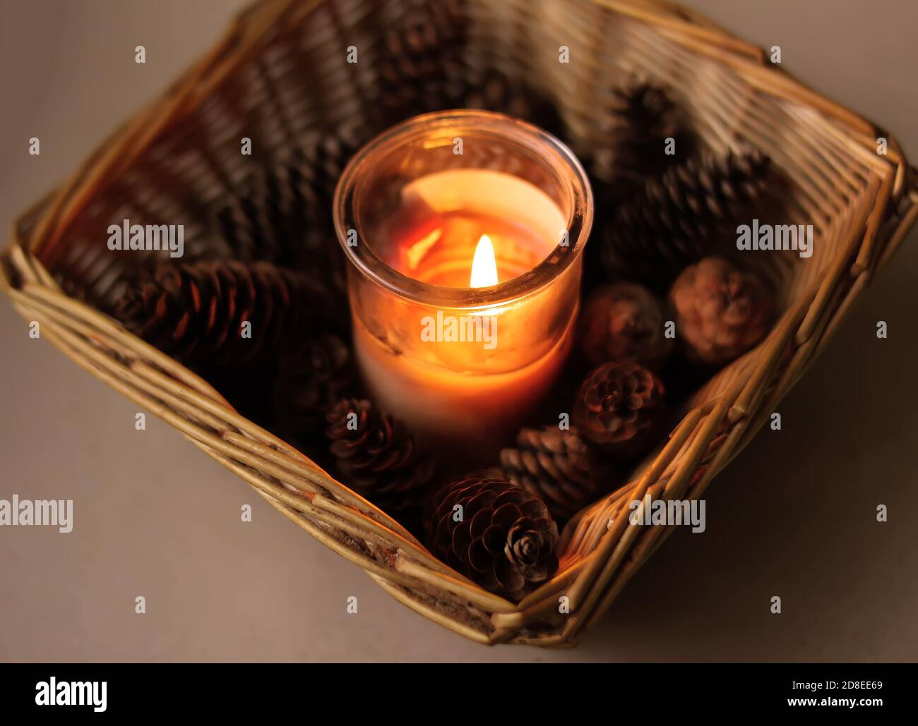 Fir-tree cones, burning candle and christmas decorations in a small ...
