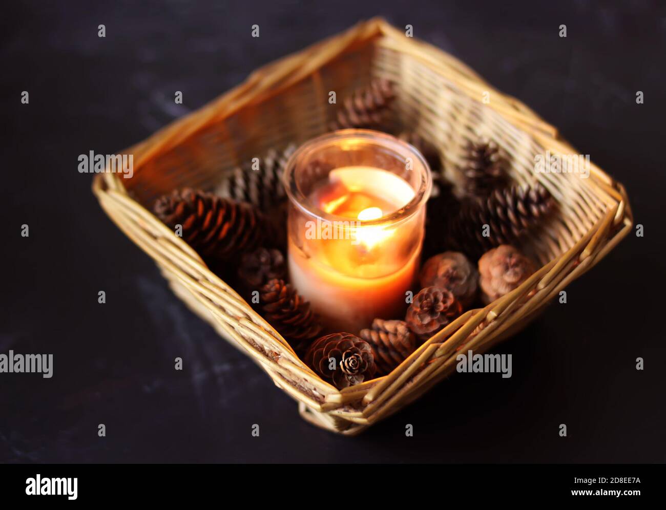 Fir-tree cones, burning candle and christmas decorations in a small ...