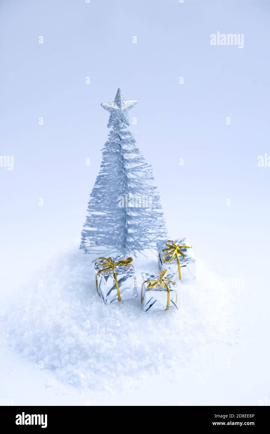 Decorative Christmas tree and gift boxes on fluffy snow background ...