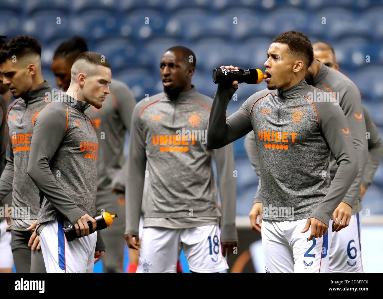 Rangers' James Tavernier (right) takes a drinks break as he warms up on the pitch prior to the beginning of the UEFA Europa League match at Ibrox Stadium, Glasgow. Stock Photo