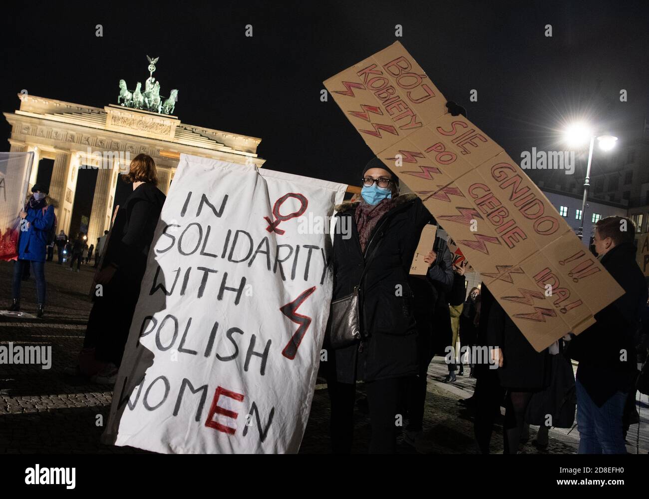 Berlin, Germany. 29th Oct, 2020. Demonstrators are standing in front of the Brandenburg Gate with posters including the inscription 'Solidarity with Polish women'. They protested here against a tightening of the abortion ban in Poland. Credit: Paul Zinken/dpa-Zentralbild/dpa/Alamy Live News Stock Photo