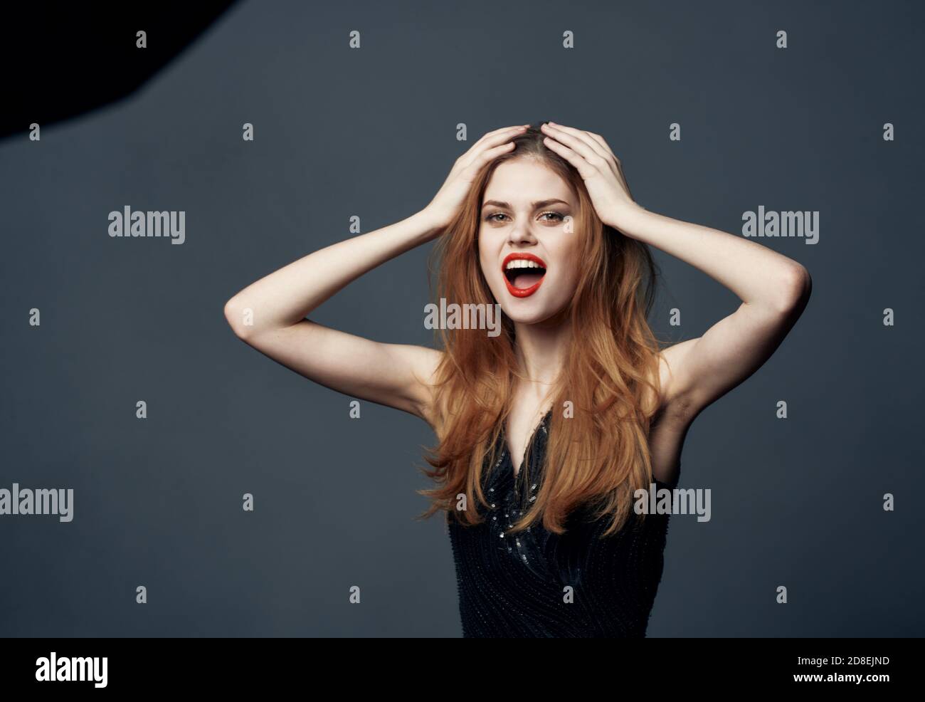 impulsive woman on a gray background indignant Look model and black dress Stock Photo Alamy