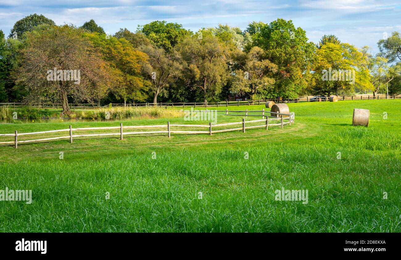 Split rail fence and haybales in a field Stock Photo