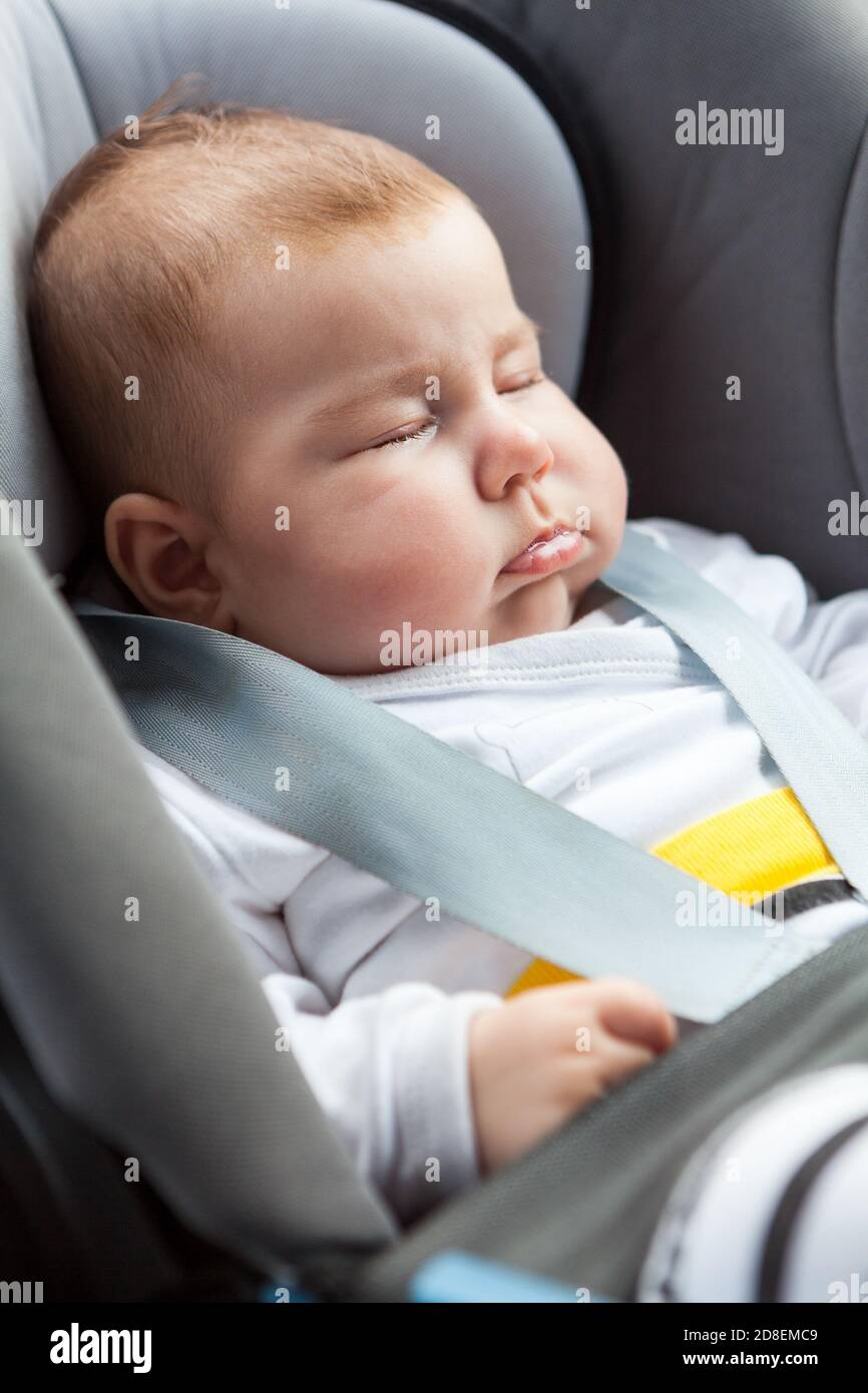 Newborn child in a baby car seat. Protection in the car. Close up view