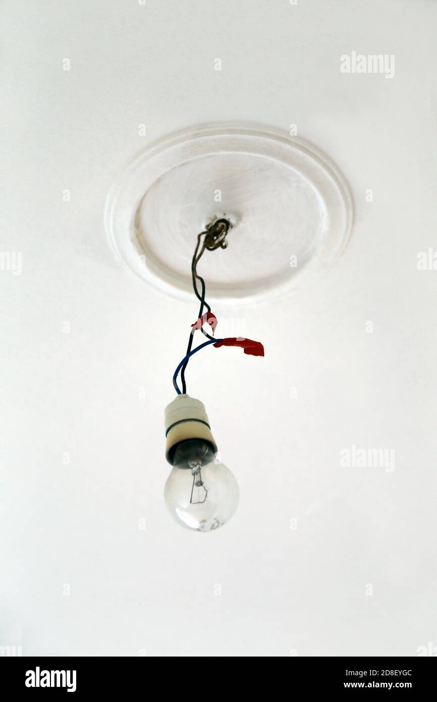 Old incandescent light bulb hanging from the ceiling with the electric