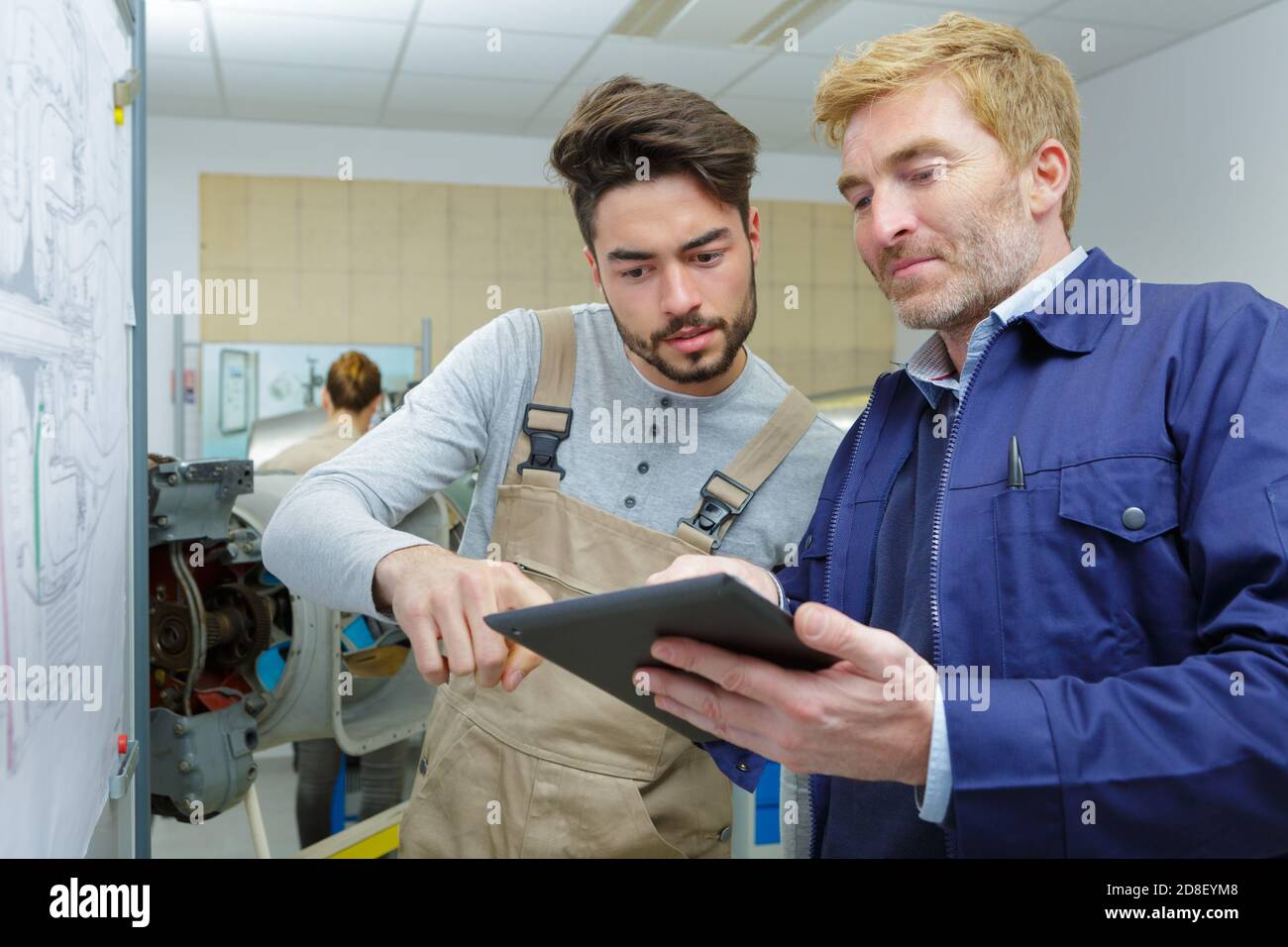two workers with a tablet in a warehouse office Stock Photo
